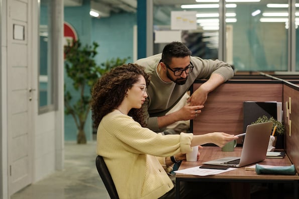 two people creating HTML elements on a computer in an office