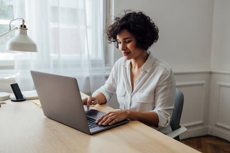 Person sitting at their desk reading article about JavaScript for backend development 